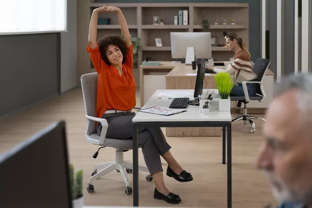 busy professional woman stretching at work