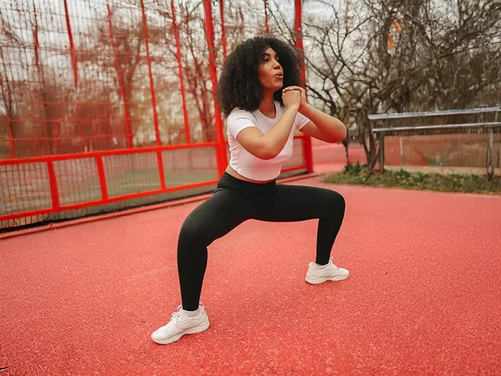 woman doing wide-stance sumo squat with a kettle weight