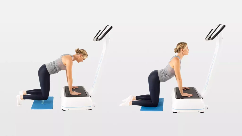 woman doing a cat-camel spinal stretch on a vibration platform