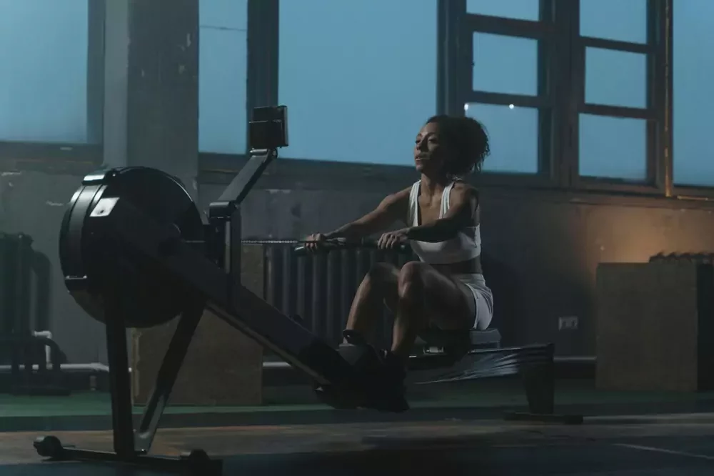 Woman using a home gym machine to work out (The Best Full-Body Machines of 2025)