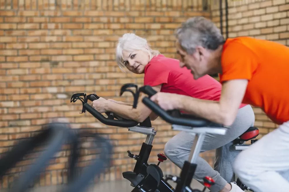 Man and woman on stationary bikes