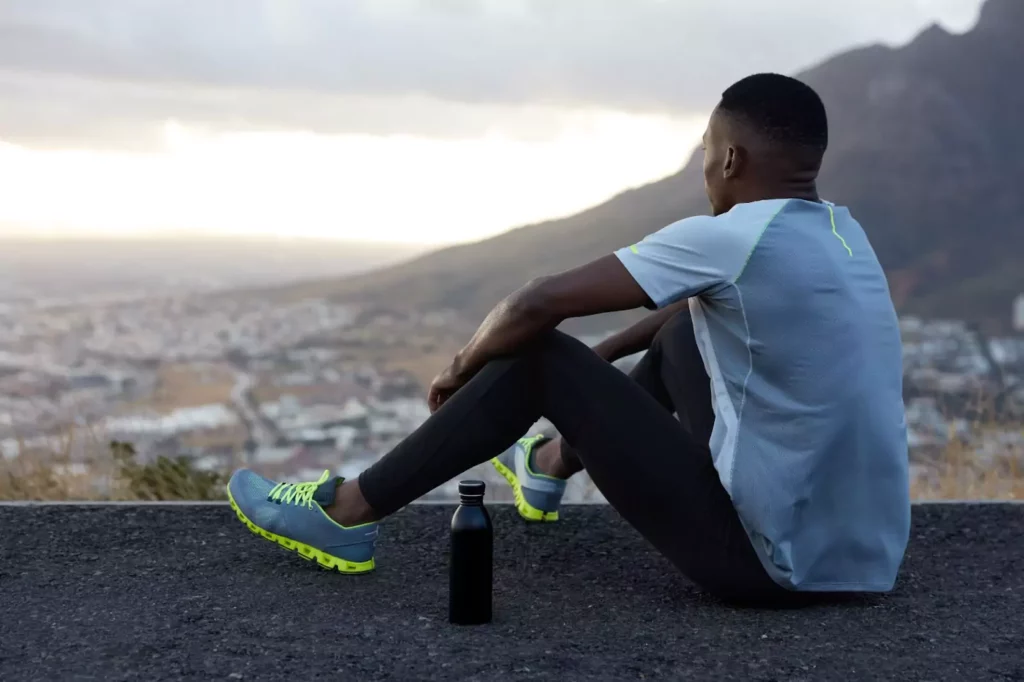 relaxed African American man drinks water after a workout (2)